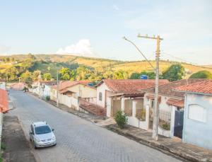 a car parked on a street in a village at CHALÉ ADOBE in Carrancas