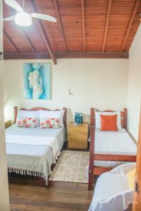 two beds in a room with wooden ceilings at CHALÉ ADOBE in Carrancas