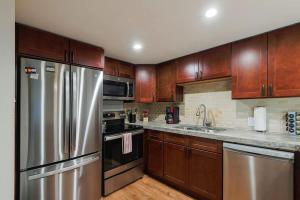 a kitchen with wooden cabinets and stainless steel appliances at Rockies Alpine Haven in Steamboat Springs