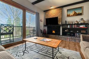 a living room with a table and a fireplace at Rockies Alpine Haven in Steamboat Springs +25 photos