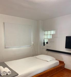 a white bedroom with a bed and a window at A&D Houses No3 in Patra
