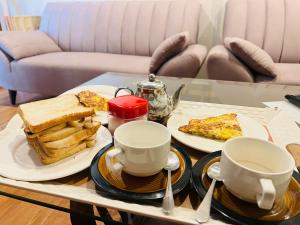 a table topped with plates of breakfast foods and cups at Royal Cottage in Murree in Murree