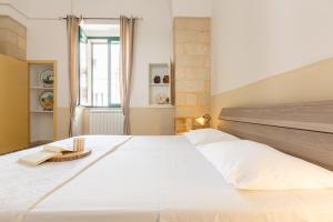 a large white bed in a room with a window at Rifugio del Sole in Cutrofiano