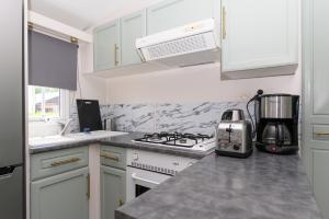 a kitchen with white cabinets and a stove top oven at La Dune d’Erdeven in Erdeven