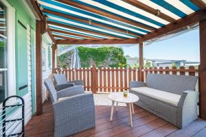 a patio with chairs and a table on a deck at La Dune d’Erdeven in Erdeven
