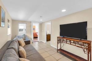 a living room with a couch and a flat screen tv at 4BR Bungalow Steps to the Beach in Seaside Heights