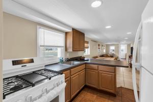 a kitchen with a stove top oven next to a sink at 4BR Bungalow Steps to the Beach in Seaside Heights