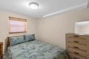 a small bedroom with a bed and a dresser at 4BR Bungalow Steps to the Beach in Seaside Heights
