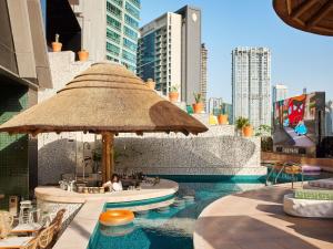 a woman sitting at a bar in a swimming pool at Mama Shelter Dubai in Dubai