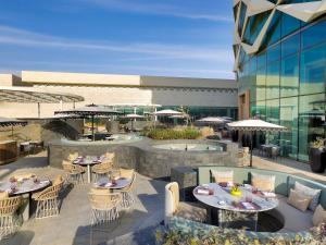 an outdoor patio with tables and chairs and a building at Sofitel Riyadh Hotel & Convention Centre in Riyadh