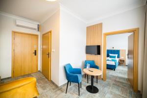 a hotel room with a table and blue chairs at Nysa Gubin in Gubin