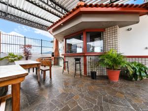 a patio with tables and chairs and a building at Hotel São Charbel in Ubatuba