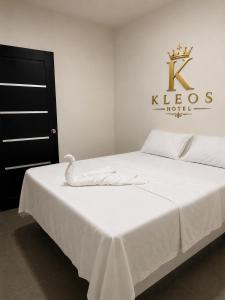 a bedroom with a bed with a white bedspread at Hotel Kleos in Cárdenas
