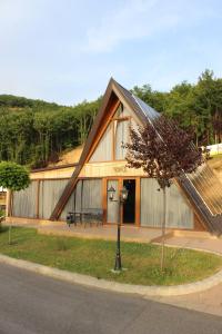 a building with a gambrel roof with a tree in front at Batllava Premium Resort Villa's in Orllan