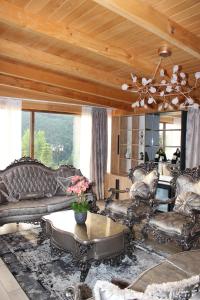 a living room with leather furniture and a ceiling at Batllava Premium Resort Villa's in Orllan