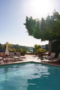 a swimming pool with chaises and chairs next to at Hodelpa Nicolás de Ovando in Santo Domingo +74 photos