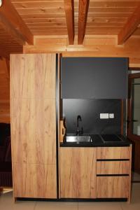 a kitchen with a sink and wooden cabinets at Batllava Premium Resort Villa's in Orllan