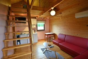 a living room with a red couch and a kitchen at Jaani Puhkemaja in Pärnu