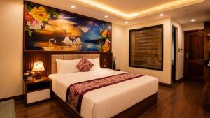 a bedroom with a bed with a painting on the wall at Lavender SaPa Hotel & Spa Right in the center of Sa Pa - Free foot soak service in Lao Cai