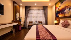 a hotel room with a bed and a table and chairs at Lavender SaPa Hotel & Spa Right in the center of Sa Pa - Free foot soak service in Lao Cai