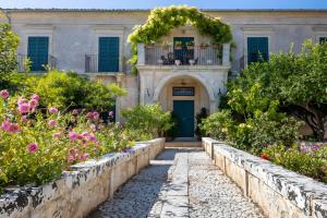 an old house with flowers in front of it at Villa Aguglie Con Piscina in Modica
