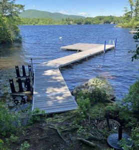a dock in the middle of a body of water at Lake Winni Cottage in Moultonborough