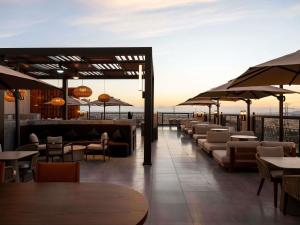 a restaurant with tables and chairs and umbrellas at Mercure Hotel Khamis Mushait by Accor in Khamis Mushayt