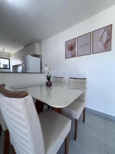 a dining room with a white table and chairs at apartamento ana julia modesto in Juazeiro do Norte