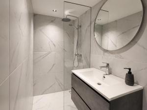 a white bathroom with a sink and a mirror at Family holiday home by beach and forest in Dirkshorn +18 photos