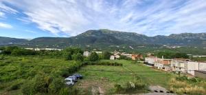 a small town with cars parked in a field with mountains at JMM Apartment in Kotor