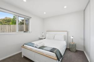 a white bedroom with a bed and a window at Stylish Rosetta River Escape in Rosetta