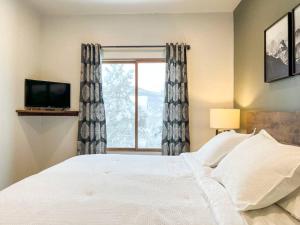 a bedroom with a large bed and a window at Alpenglow Bungalow in Steamboat Springs