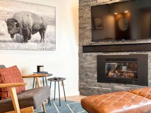 a living room with a fireplace with a bull on the wall at Alpenglow Bungalow in Steamboat Springs