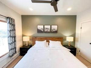 a bedroom with a large white bed with two lamps at Alpenglow Bungalow in Steamboat Springs +37 photos