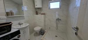 a white bathroom with a shower and a toilet at JMM Apartment in Kotor