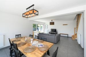 a dining room with a table and a couch at Maison de vacances Plouharnel 3star in Plouharnel