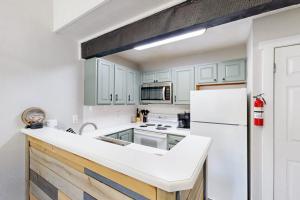 a kitchen with white cabinets and a white refrigerator at The Pocono Loft in Lake Harmony