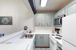 a white kitchen with a sink and a refrigerator at The Pocono Loft in Lake Harmony +22 photos