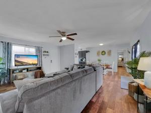a living room with a large couch and a tv at Silk Oak Tempe in Tempe