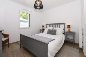 a bedroom with a large bed and a window at Maison de vacances Plouharnel 3star in Plouharnel