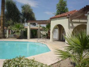 a swimming pool in front of a house with a building at Silk Oak Tempe in Tempe