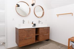 a bathroom with two sinks and two mirrors at Maison de vacances Plouharnel 3star in Plouharnel +21 photos