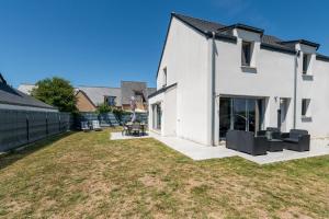 a white house with a yard at Maison de vacances Plouharnel 3star in Plouharnel