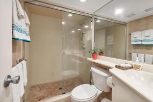 a bathroom with a shower and a toilet and a sink at Oceanwood 109 in Saint Simons Island +12 photos