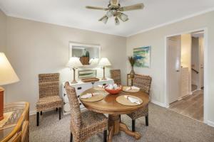 a living room with a dining room table and chairs at Oceanwood 109 in Saint Simons Island
