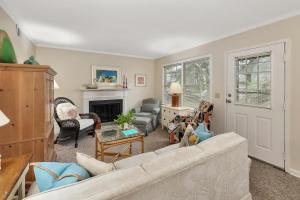 a living room with a couch and a fireplace at Oceanwood 109 in Saint Simons Island