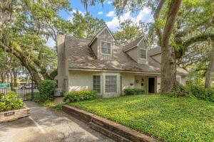 a house with a tree in the yard at Oceanwood 109 in Saint Simons Island