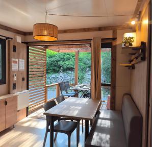 a kitchen and dining room with a table and chairs at Camping Le Boem in Balazuc