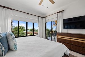 a bedroom with a large bed and a large window at Oceanview Condo Across From Beach with Resort Pool in Tamarindo +12 photos