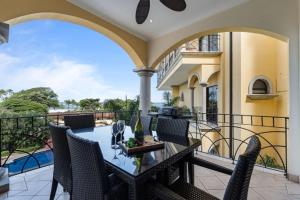 an outdoor patio with a table and chairs on a balcony at Oceanview Condo Across From Beach with Resort Pool in Tamarindo